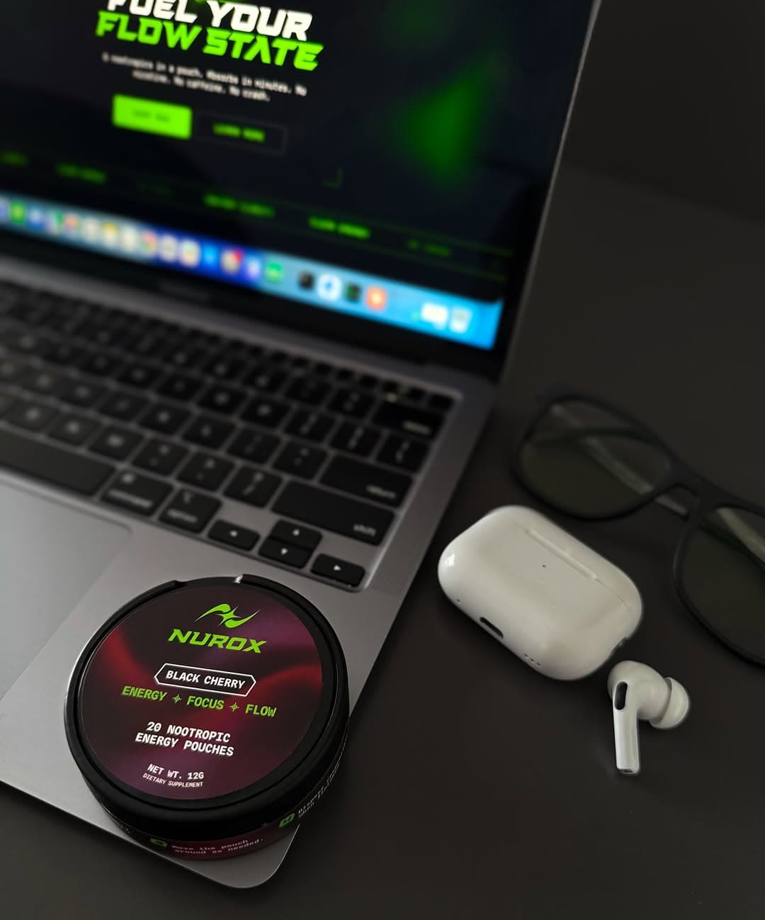 NUROX tin on a desk next to a MacBook